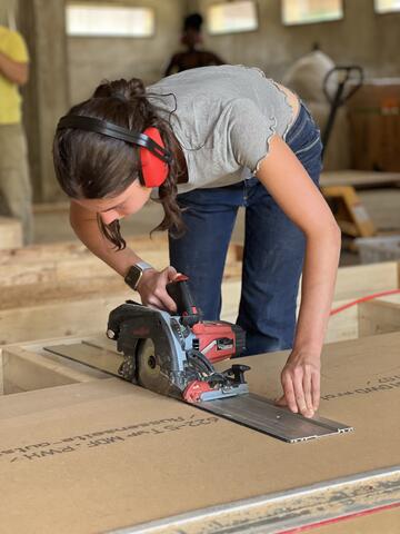 étudiante en train de scier du bois