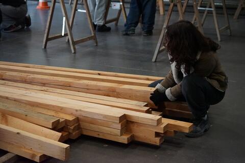 étudiante près d'un tas de bois