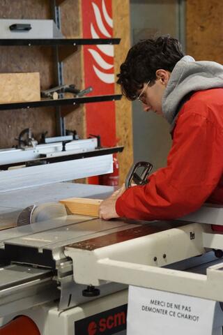 étudiant découpant du bois